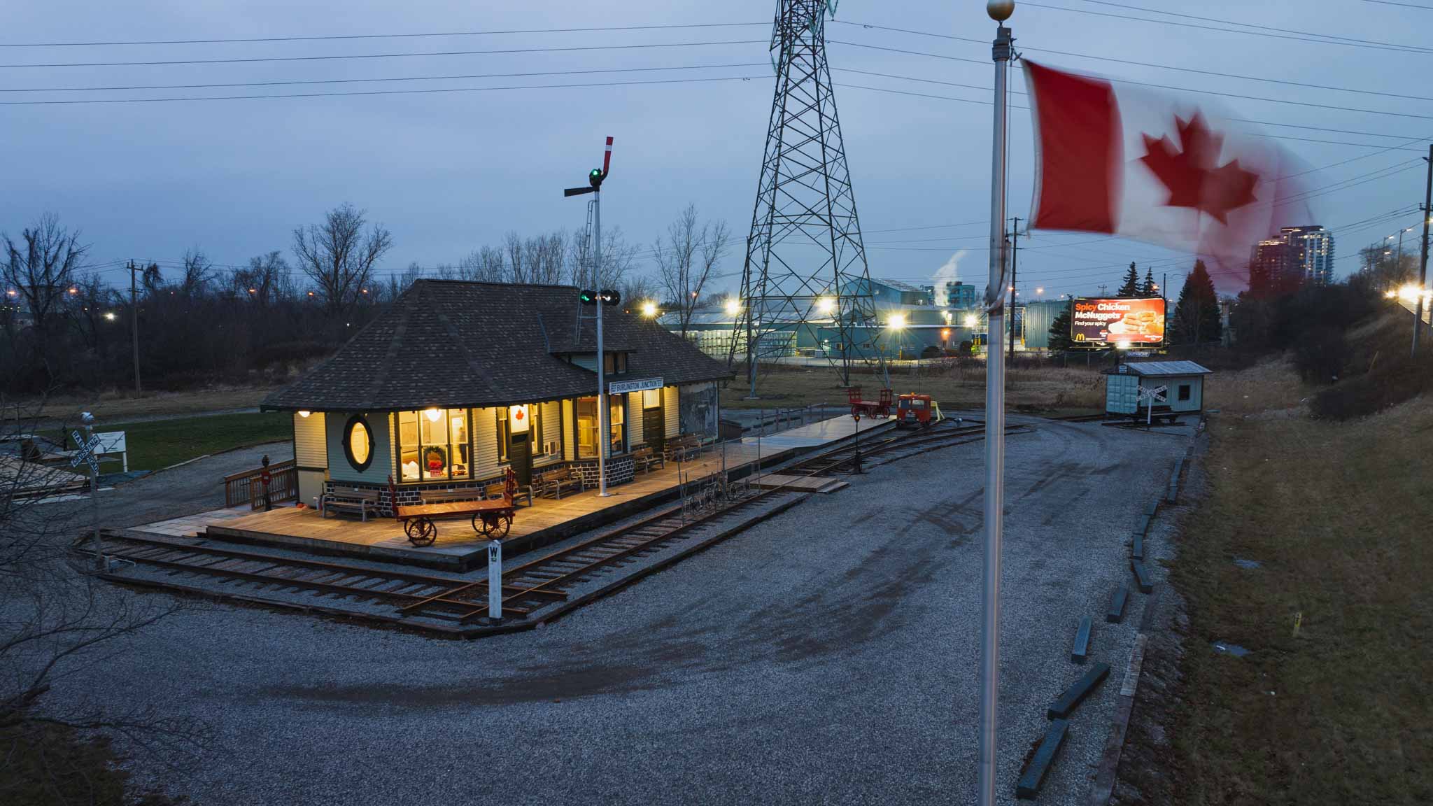 An aerial photo of the fully restored Freeman Station in Burlington, ON, seen at dusk as the Canadian flag wave out front.